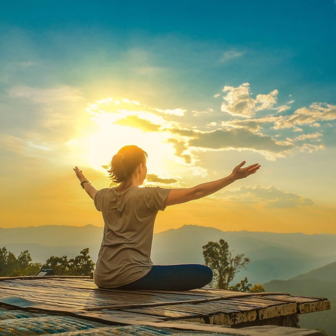 Woman doing yoga overlooking the sunset