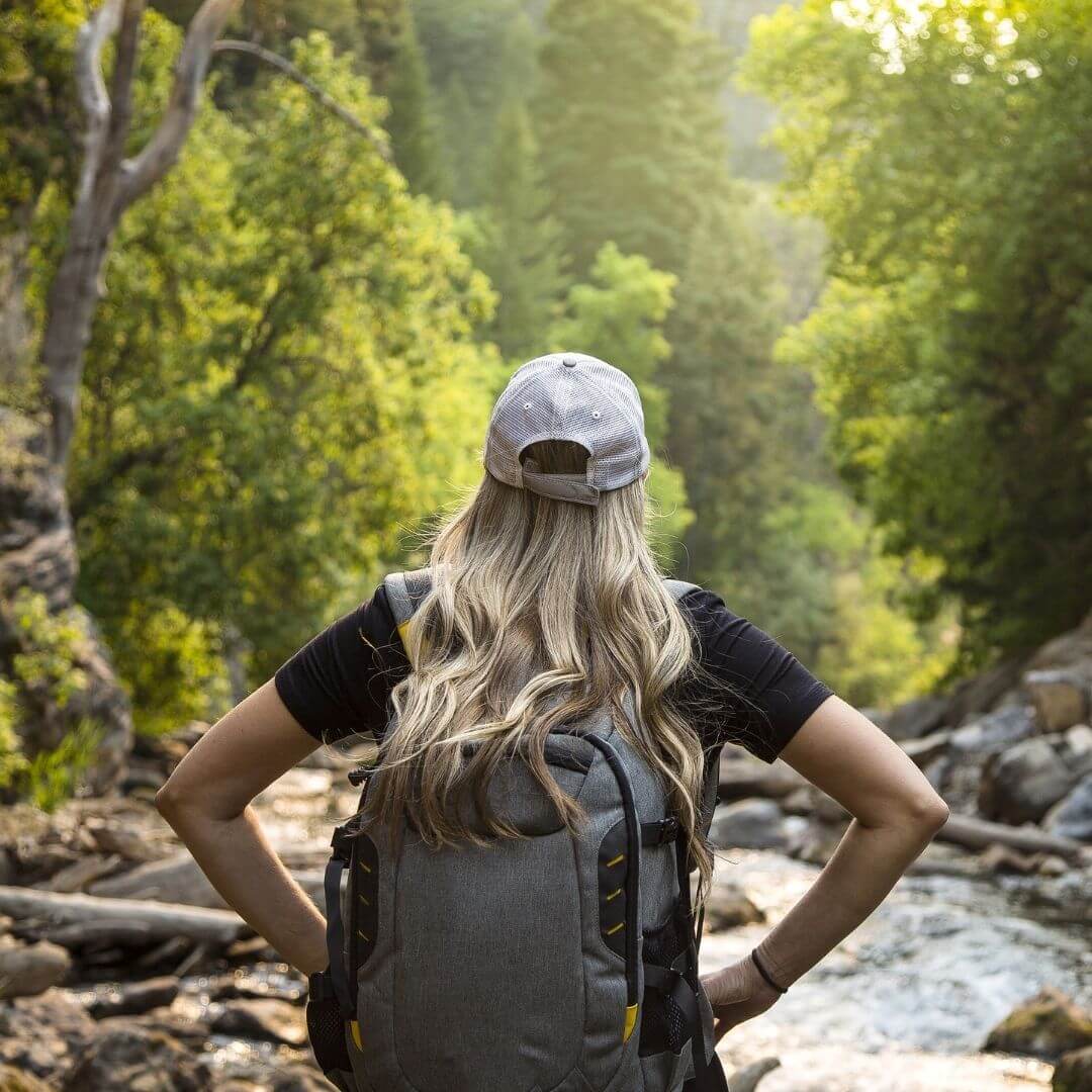 Woman in nature looking at a river 